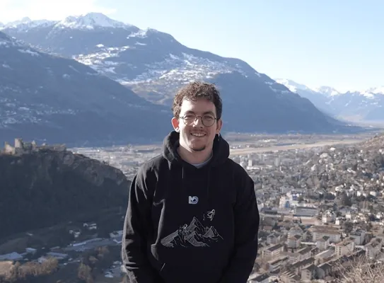 Brice Mabillard en extérieur, une ville et des montagnes en arrière-plan