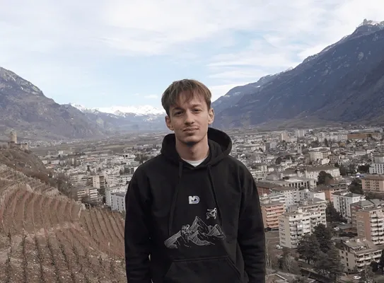 Théo Mayoraz en extérieur, une ville et des montagnes en arrière-plan